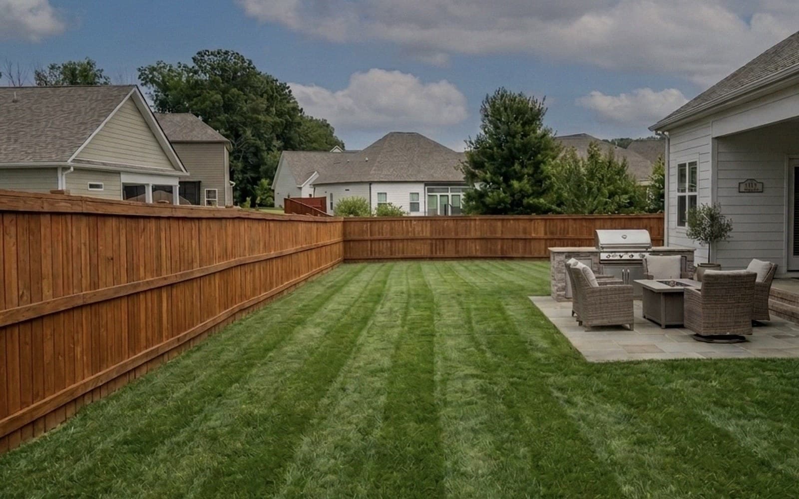 Backyard with cedar fence and fresh mowing stripes by Stripe Authority in Fairview TN
